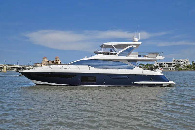 Slide: The Image of 2022 Azimut 72 FLY yacht on calm waters with a cityscape background. - 10