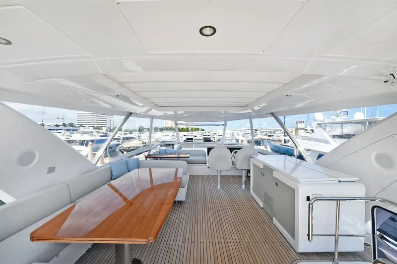 Slide: The Image of Luxurious 2022 Azimut 72 FLY yacht flybridge with seating, dining table, and marina view. - 4