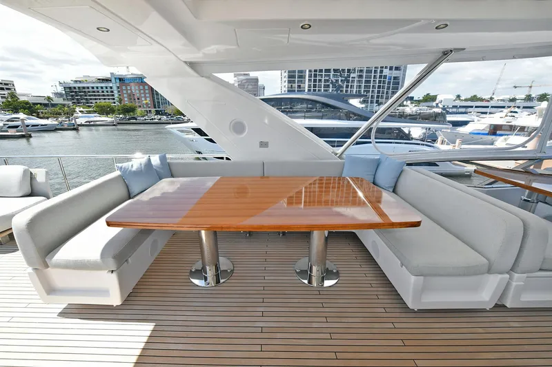 Slide: The Image of Luxury outdoor seating area on 2022 Azimut 72 FLY yacht, featuring a polished wooden table. - 43