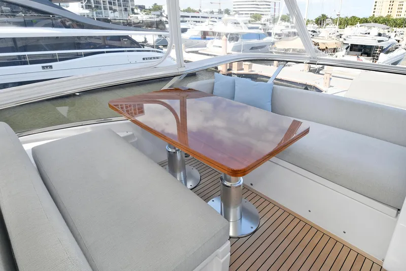 Slide: The Image of Luxury seating area on 2022 Azimut 72 FLY yacht with wooden table and marina view. - 48