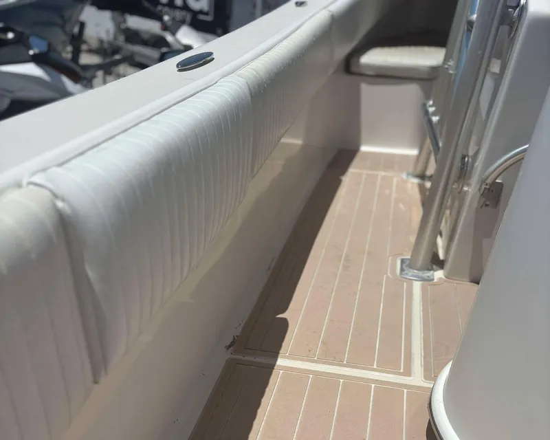 Slide: The Image of 2009 Andros Tarpon 26 boat interior with cushioned seating and wooden flooring. - 13