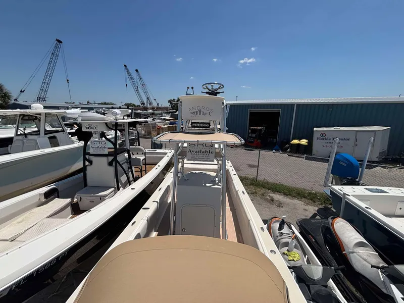 Slide: The Image of 2009 Andros Tarpon 26 boat docked in a marina with cranes and storage buildings. - 3