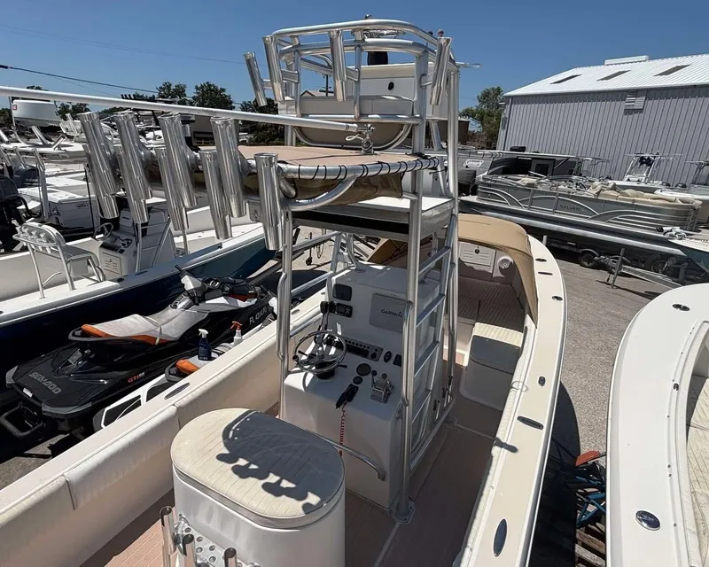 Slide: The Image of 2009 Andros Tarpon 26 boat with elevated helm, docked in a marina under clear skies. - 9