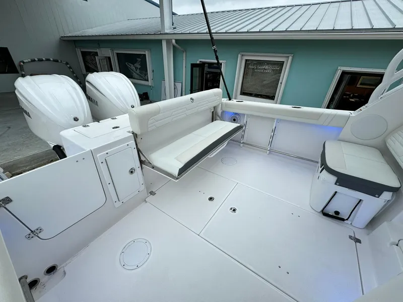 Slide: The Image of 2024 Edgewater 280cx boat interior with seating and dual outboard engines. - 12