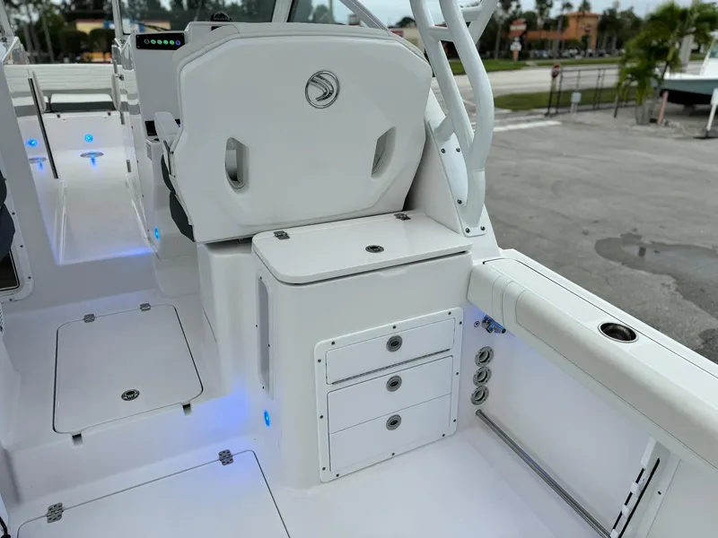 Slide: The Image of 2024 Edgewater 280cx boat interior with storage compartments and seating. - 15