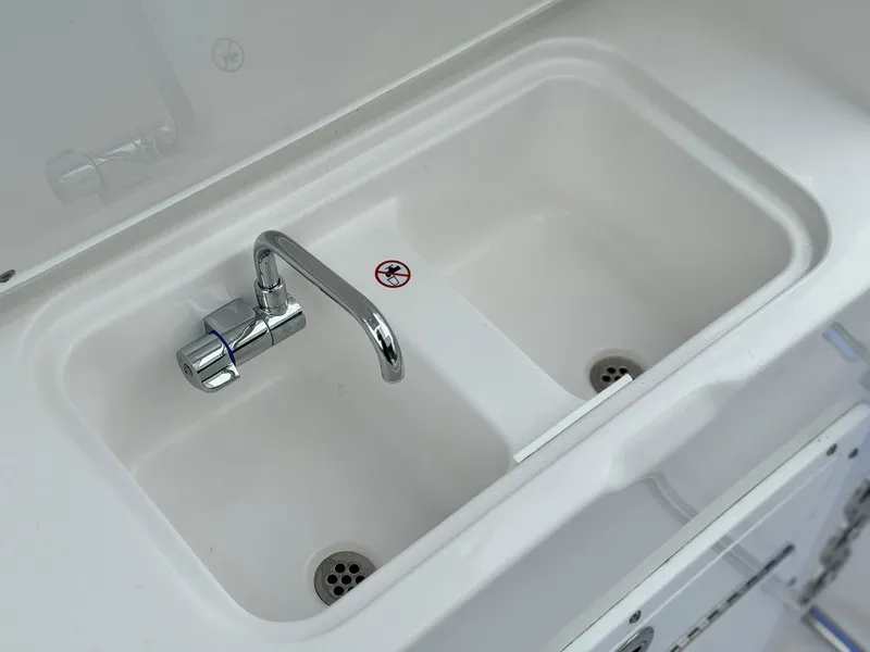 Slide: The Image of 2024 Edgewater 280cx boat sink with dual basins and chrome faucet. - 16