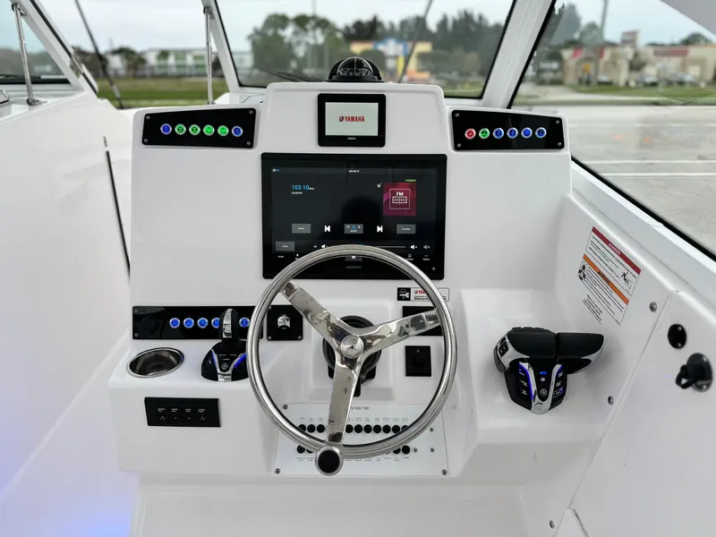 Slide: The Image of 2024 Edgewater 280cx boat helm with modern controls and touchscreen display. - 18