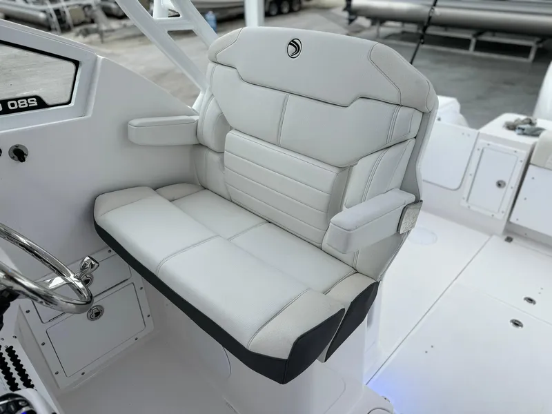 Slide: The Image of 2024 Edgewater 280cx boat captain's seat with white upholstery and armrests. - 19
