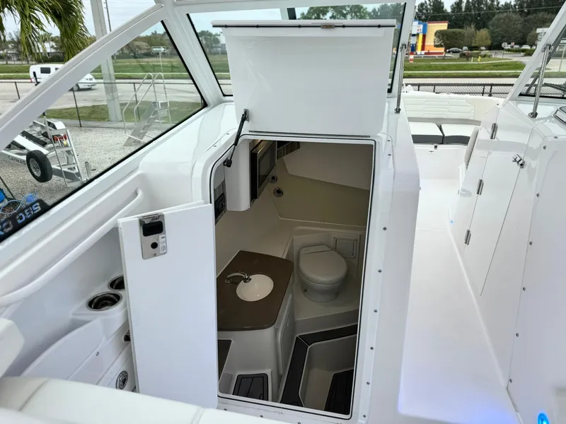 Slide: The Image of 2024 Edgewater 280cx boat interior with open bathroom compartment. - 21