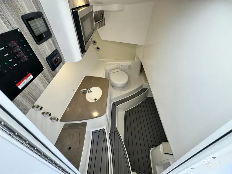 Slide: The Image of 2024 Edgewater 280cx boat interior with kitchenette, sink, and toilet. - 22