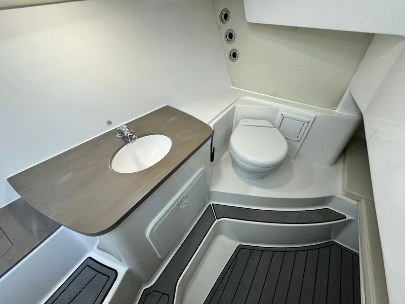Slide: The Image of 2024 Edgewater 280cx boat bathroom with sink and toilet. - 23