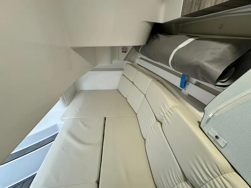 Slide: The Image of 2024 Edgewater 280cx cabin interior with beige seating and storage area. - 27