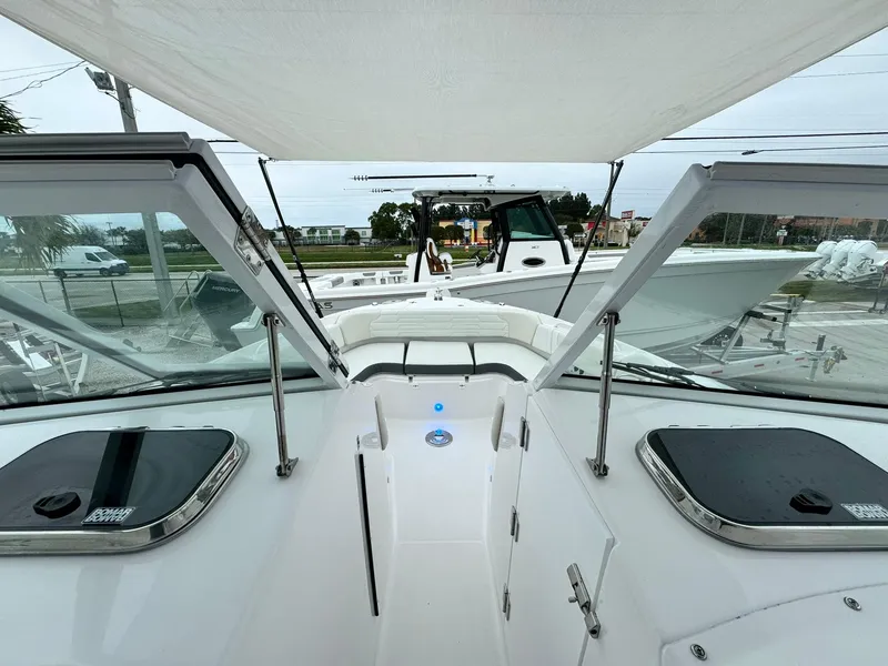Slide: The Image of 2024 Edgewater 280cx boat interior with open hatches and canopy. - 28