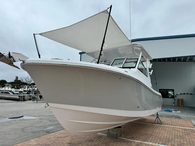 Slide: The Image of 2024 Edgewater 280cx boat with canopy in a marina. - 4
