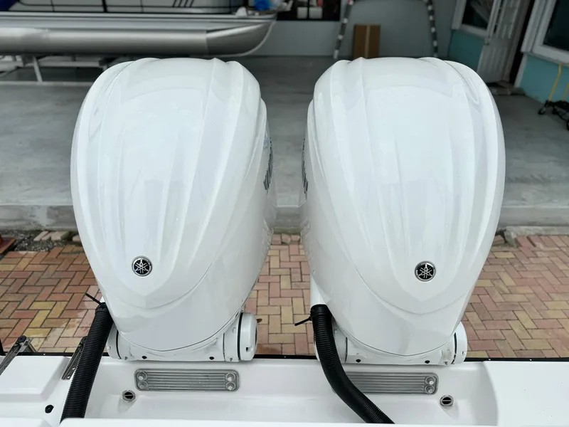 Slide: The Image of 2024 Edgewater 280cx twin outboard engines in a marina. - 9