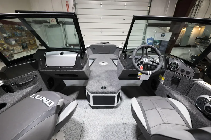 Slide: The Image of 2024 Lund 1675 Adventure Sport boat interior with steering wheel and seating. - 12