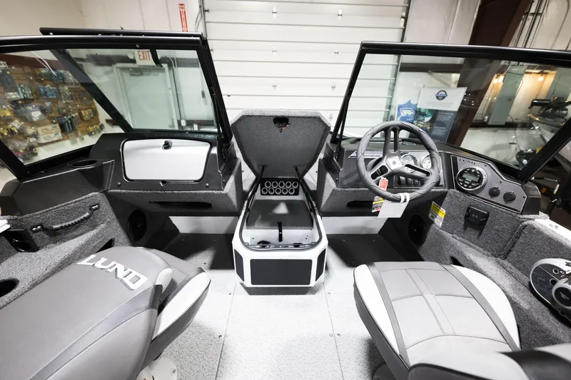 Slide: The Image of 2024 Lund 1675 Adventure Sport boat interior with steering wheel and seating. - 13