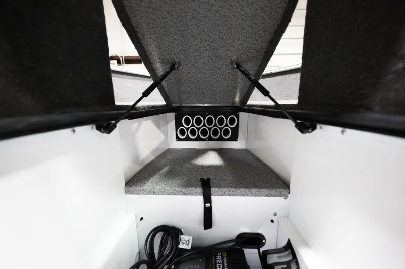 Slide: The Image of 2024 Lund 1675 Adventure Sport interior storage compartment with rod holders and equipment. - 14