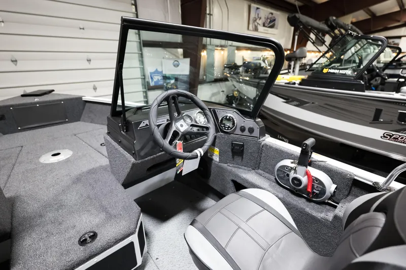 Slide: The Image of 2024 Lund 1675 Adventure Sport boat interior with steering wheel and control panel. - 15