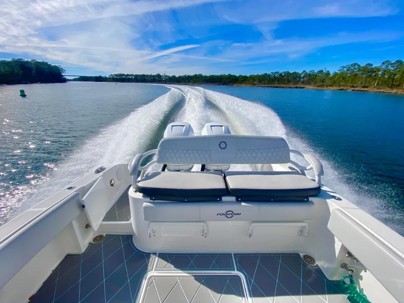 Slide: The Image of 2022 Fountain 34 Tournament Edition boat cruising on a scenic lake. - 32