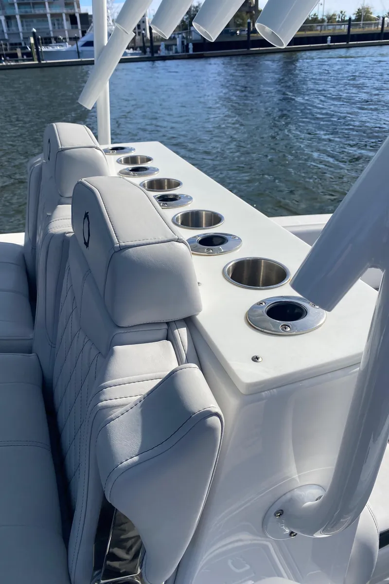 Slide: The Image of 2022 Fountain 34 Tournament Edition boat with rod holders and cup holders by the water. - 39