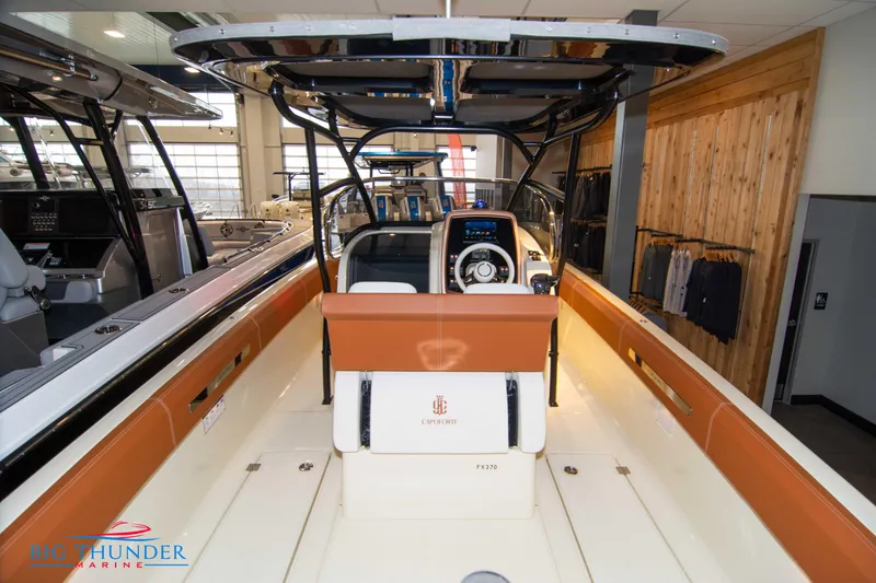 Slide: The Image of 2024 Capoforte FX270 boat interior with helm, seating, and modern design in showroom. - 20
