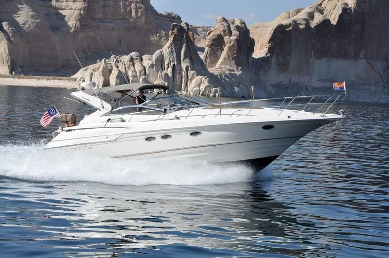 The Image of 2001 Regal 4160 Commodore yacht cruising on a scenic lake with rocky cliffs. - 0