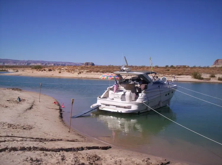 Slide: The Image of 2001 Regal 4160 Commodore yacht anchored on a sandy shore. - 16