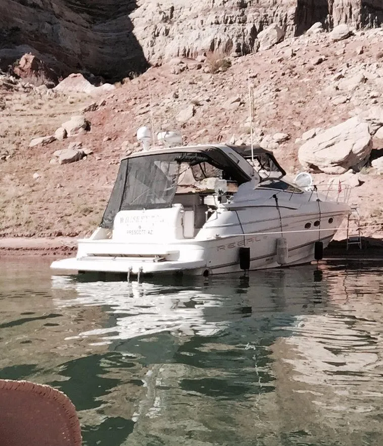 Slide: The Image of 2001 Regal 4160 Commodore yacht docked by rocky shoreline. - 25