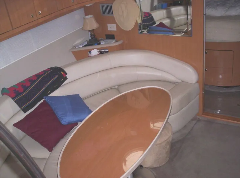 Slide: The Image of Interior of 2001 Regal 4160 Commodore yacht with curved seating and wooden table. - 6
