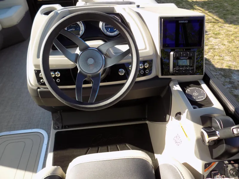 Slide: The Image of 2024 Barletta C22CC boat dashboard with steering wheel and control panel. - 16