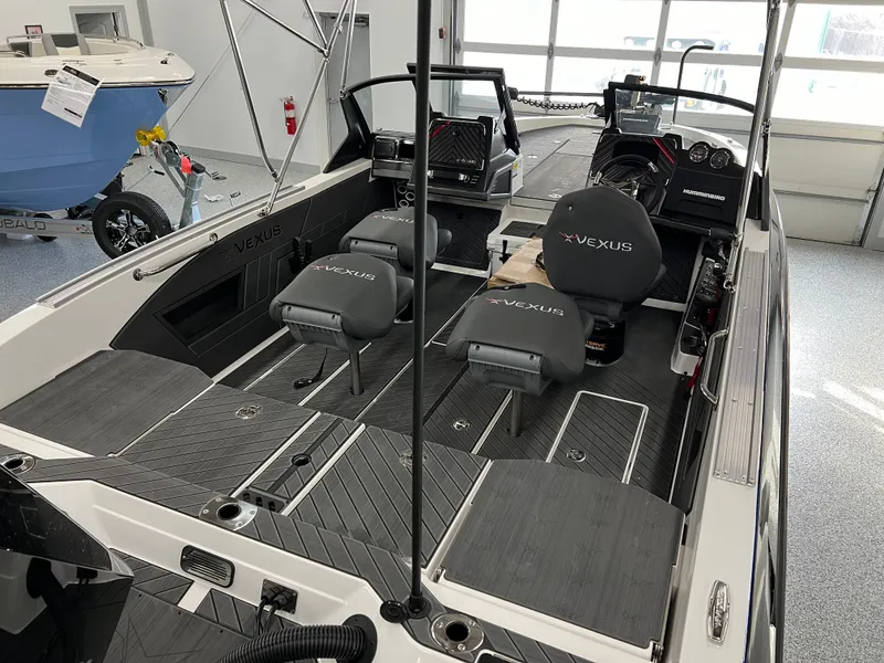 Slide: The Image of 2024 Vexus DVX 20S boat interior with seating and dashboard in showroom. - 12