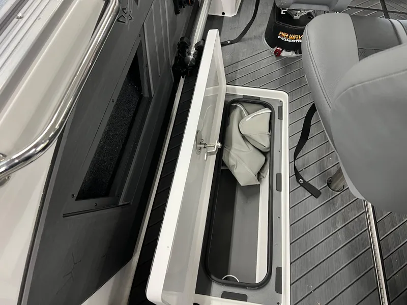 Slide: The Image of 2024 Vexus DVX 20S boat interior storage compartment with gray seat and accessories. - 48