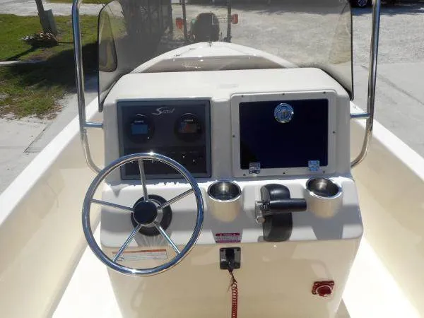 Slide: The Image of 2024 Scout 175 Sportfish boat console with steering wheel and navigation controls. - 3