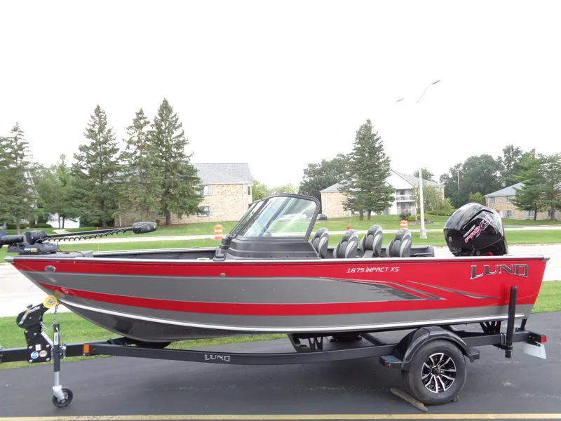 The Image of 2024 Lund 1875 Impact XS boat on trailer, red and gray design. - 0