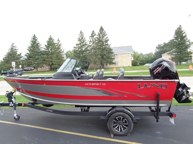 Slide: The Image of 2024 Lund 1875 Impact XS boat on trailer, red and gray design. - 14