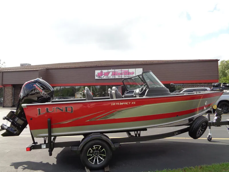 Slide: The Image of 2024 Lund 1875 Impact XS boat on trailer, parked outside a building. - 21