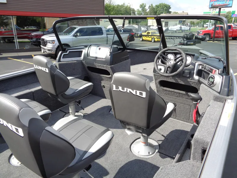 Slide: The Image of 2024 Lund 1875 Impact XS boat interior with seating and dashboard. - 24