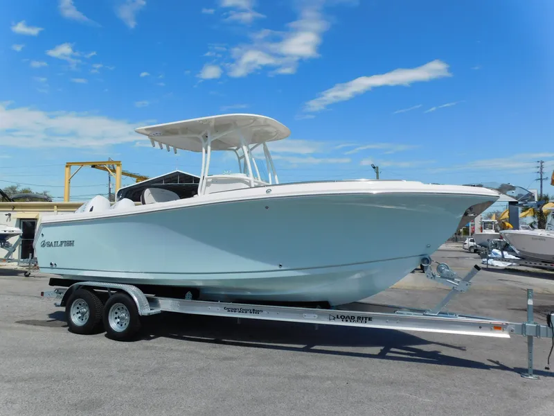 The Image of 2024 Sailfish 242 CC center console boat on a trailer under a clear blue sky. - 1