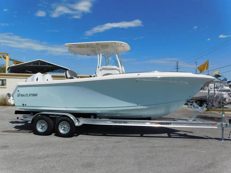 Slide: The Image of 2024 Sailfish 242 CC boat on a trailer under a clear blue sky. - 2