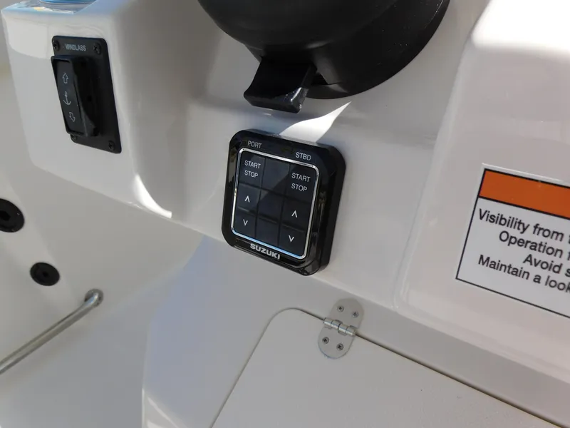 Slide: The Image of Control panel of 2024 Sailfish 242 CC boat with Suzuki start/stop buttons. - 21