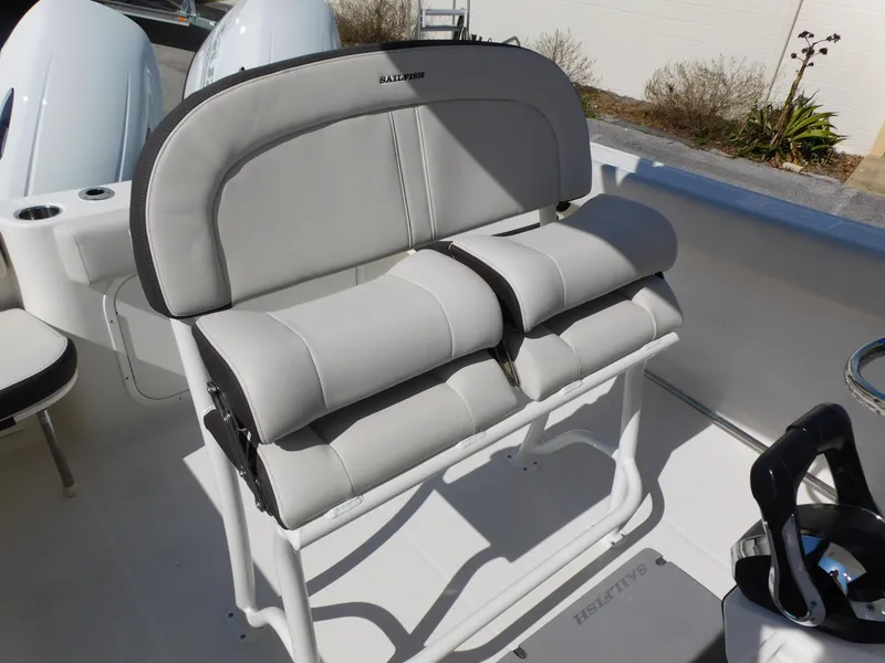 Slide: The Image of 2024 Sailfish 242 CC boat with cushioned seating and dual outboard motors. - 26