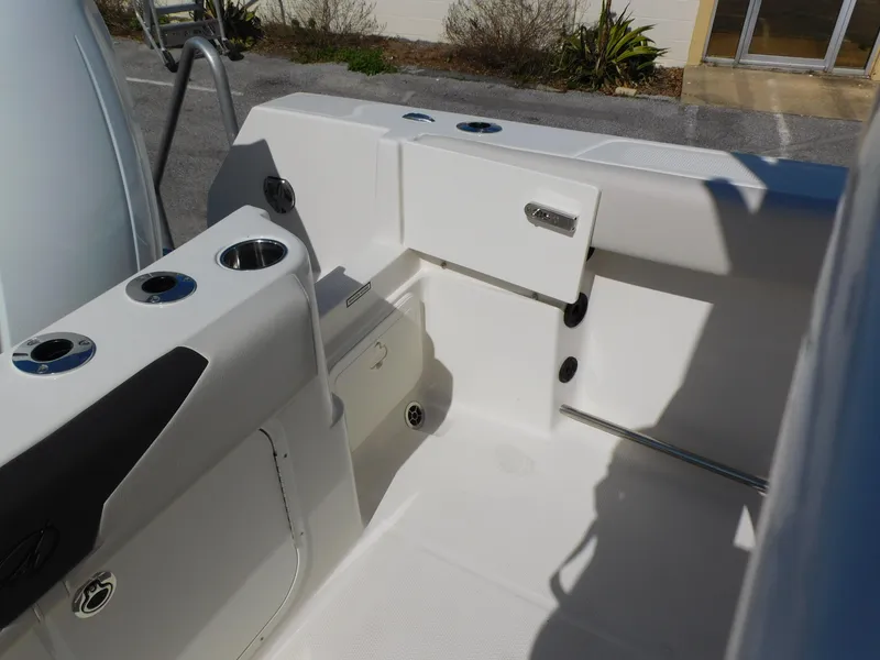 Slide: The Image of 2024 Sailfish 242 CC boat interior, featuring storage compartments and cup holders. - 37