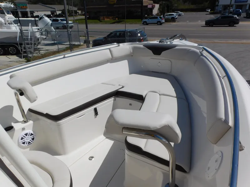 Slide: The Image of 2024 Sailfish 242 CC boat interior with white cushioned seating and storage compartments. - 9