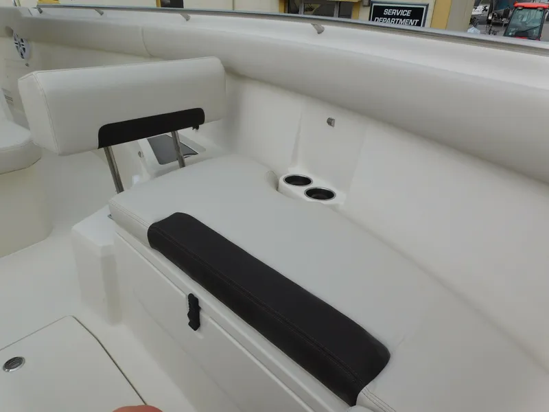 Slide: The Image of 2024 Sailfish 312 CC boat interior seating with cup holders and storage compartment. - 11