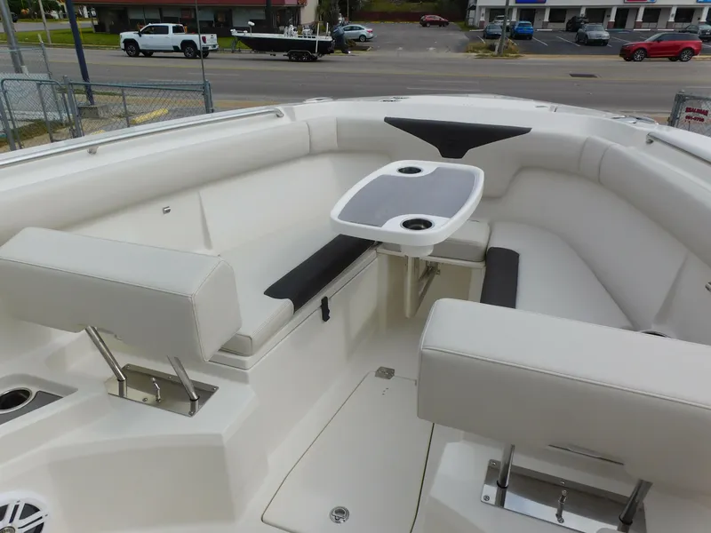Slide: The Image of 2024 Sailfish 312 CC boat interior with cushioned seating and table. - 14