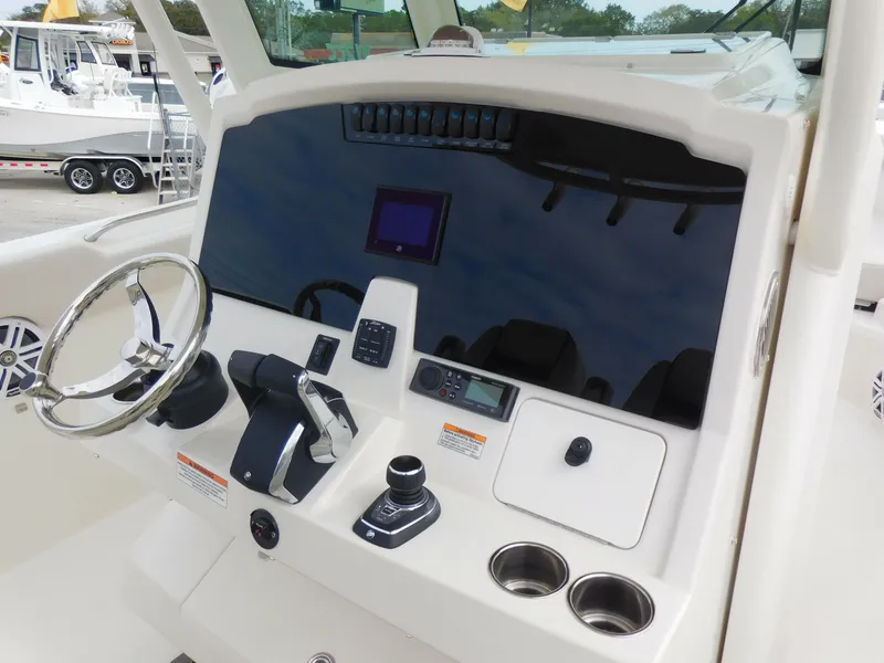 Slide: The Image of 2024 Sailfish 312 CC boat dashboard with steering wheel and control panel. - 25