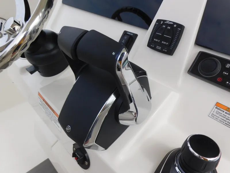 Slide: The Image of 2024 Sailfish 312 CC boat control panel with throttle and steering wheel. - 30