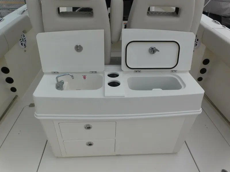 Slide: The Image of 2024 Sailfish 312 CC boat interior with sink, storage compartments, and cup holders. - 40