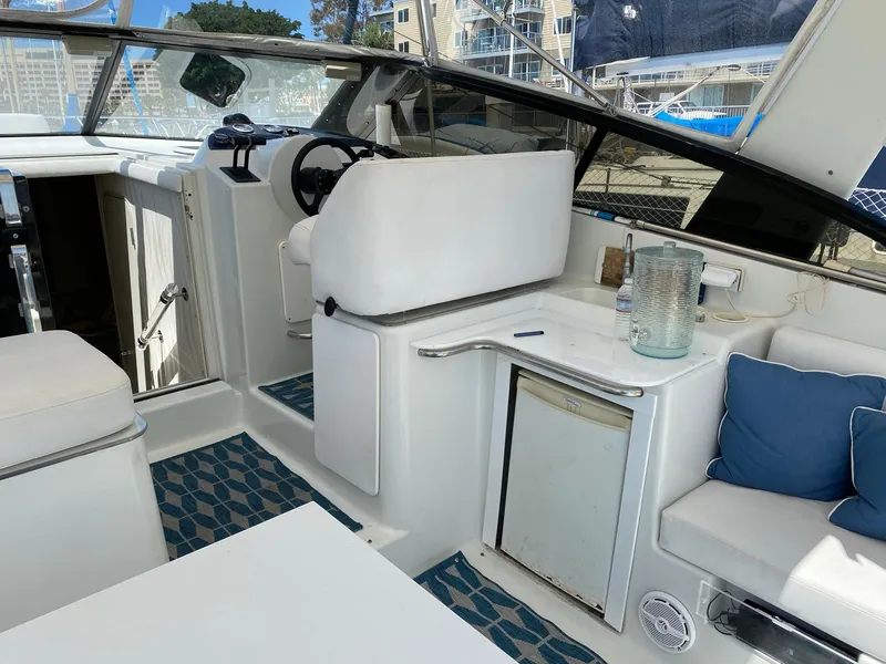 Slide: The Image of 1993 Silverton 38 Express boat interior with helm, seating, and mini fridge. - 10